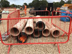 Two construction companies have been fined a combined total of £120,000 after a groundworker suffered horrific injuries when heavy drainage pipes fell on top of him.